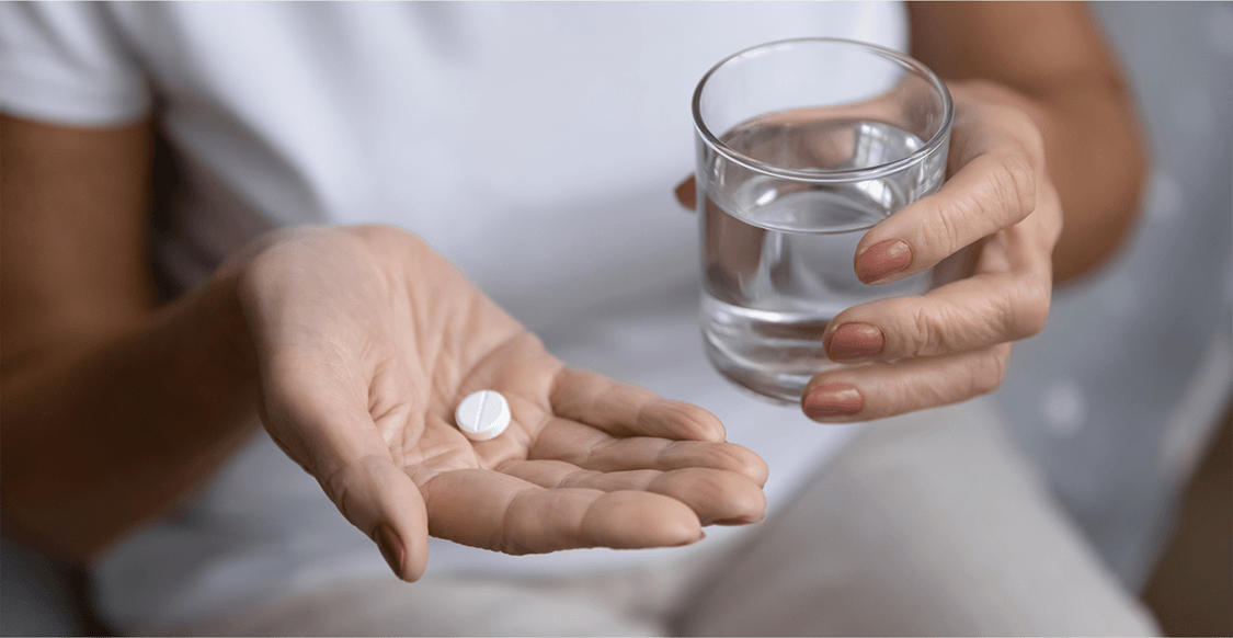 Image of woman taking an aspirin